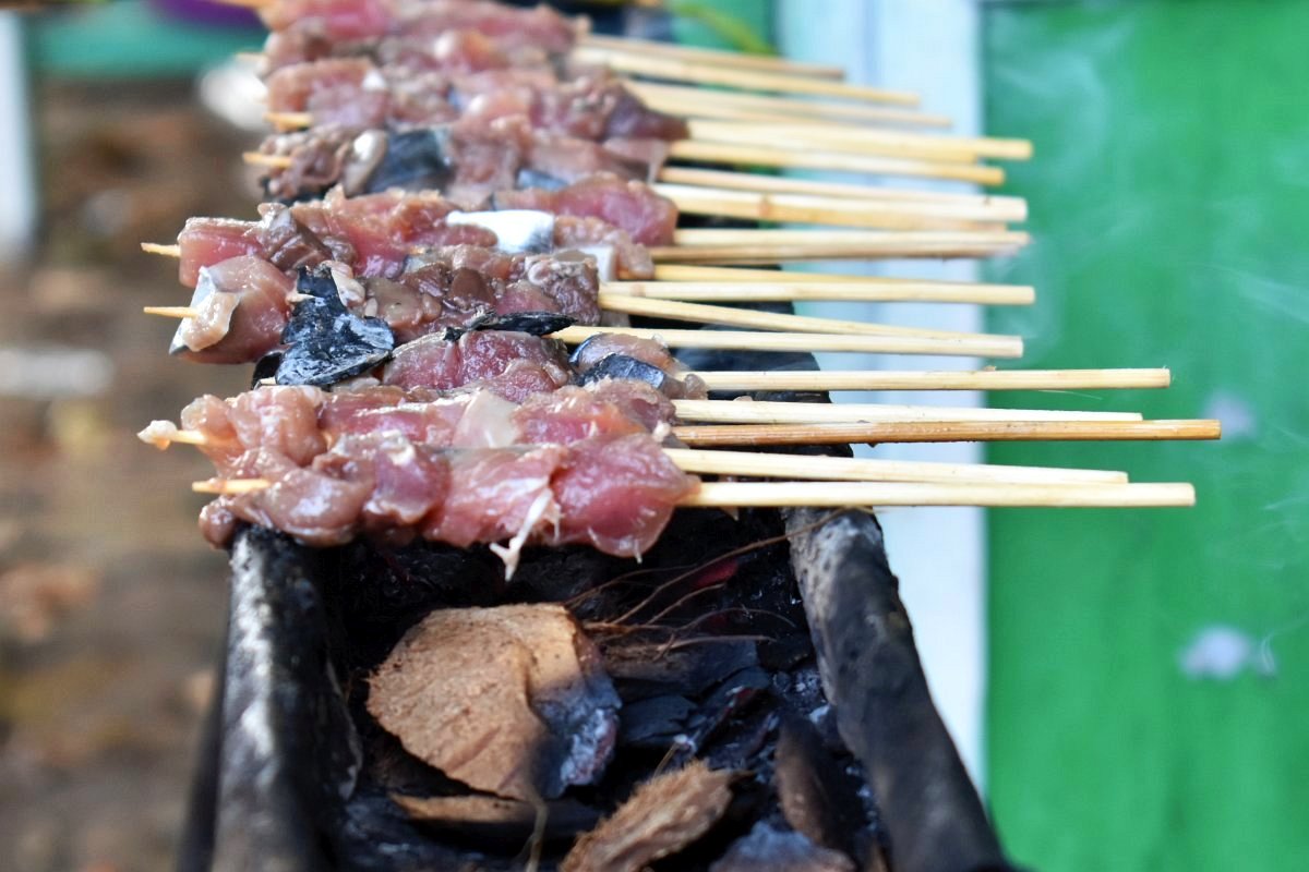 meat skewers over coconut charcoal