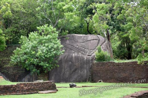 A whole building was perched on this boulder at some point. Now only the holes that supported the foundations remain.